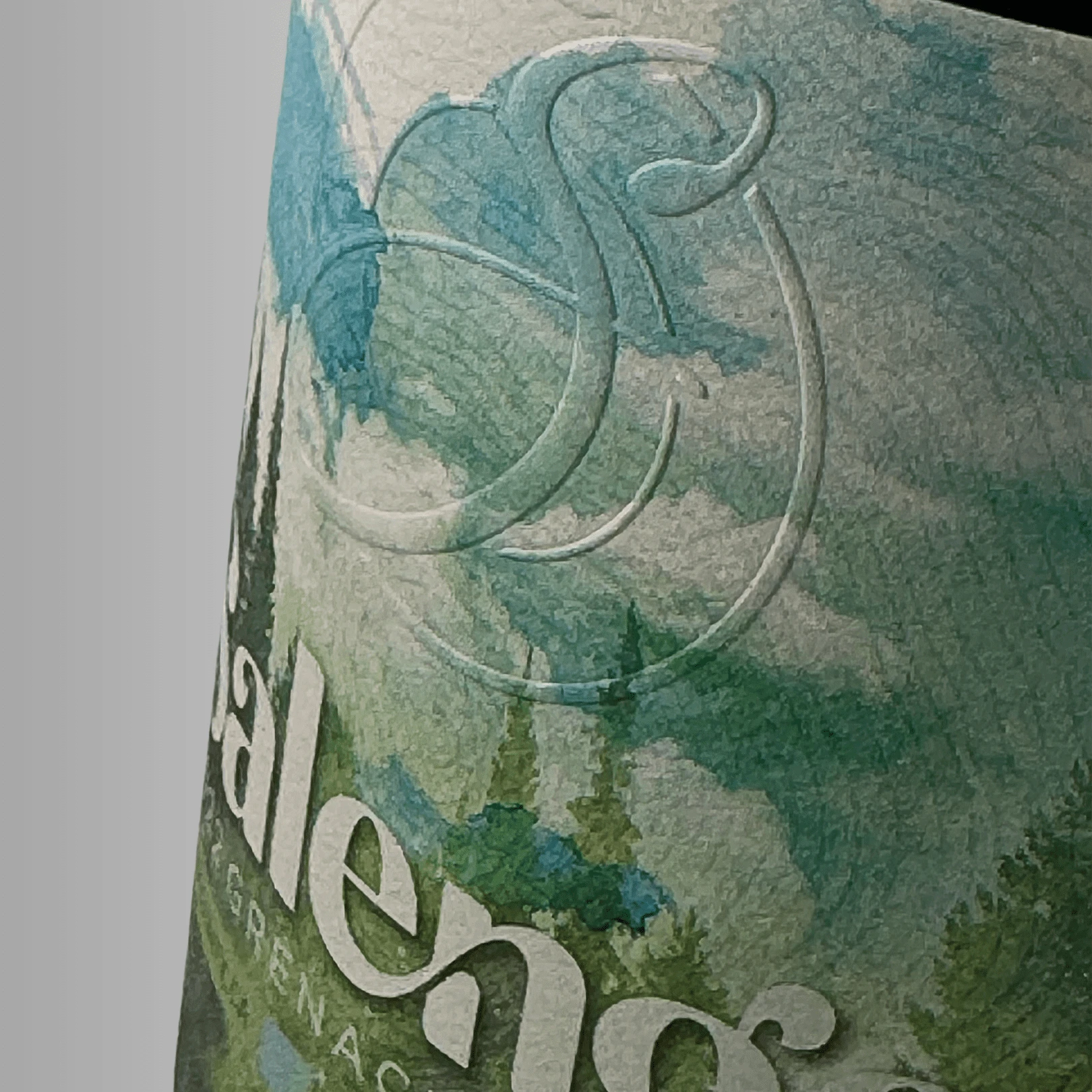 Wine bottle label featuring a watercolor-inspired illustration in soft green and blue tones