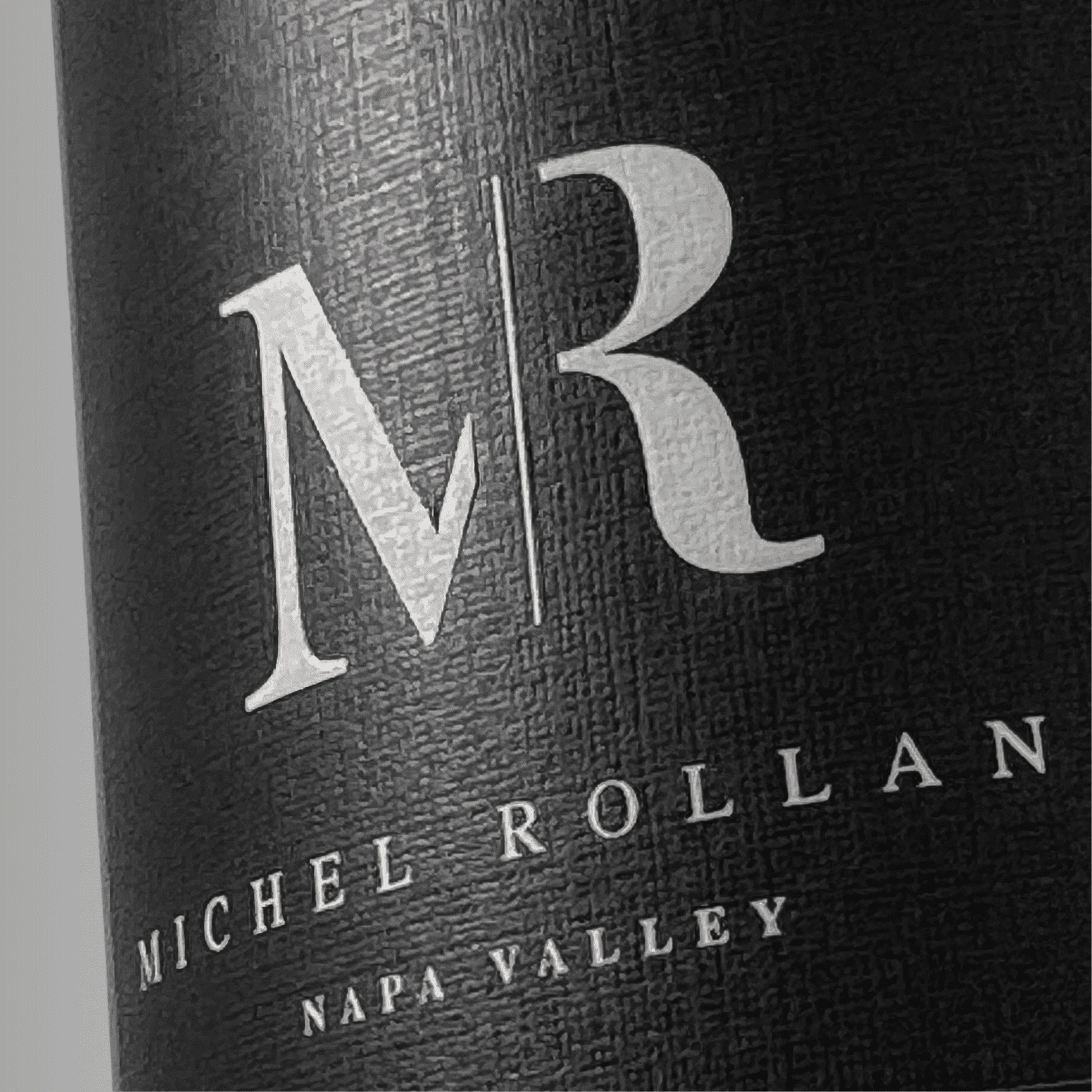 Close-up of a matte black wine label with clean white typography, showcasing modern design and premium label printing
